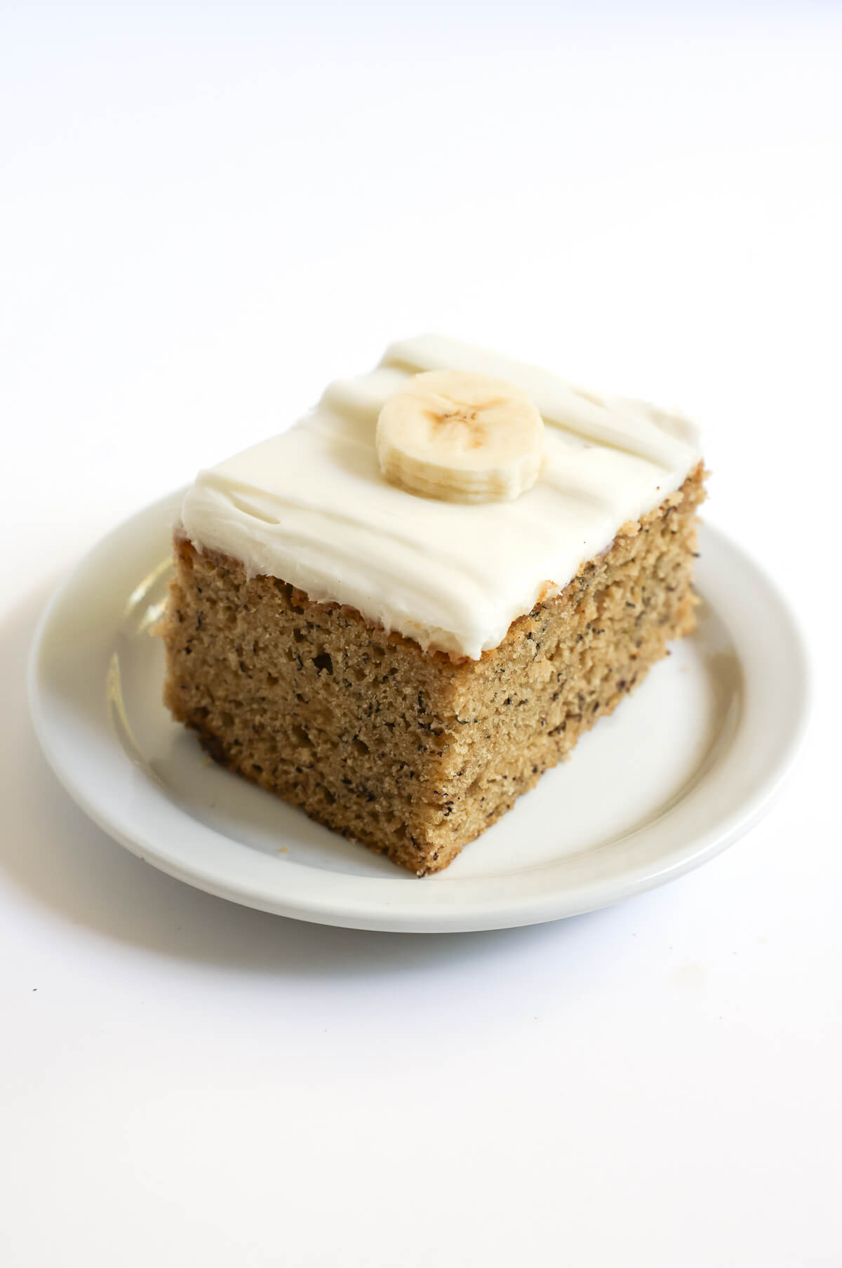 slice of vegan banana cake on white plate.