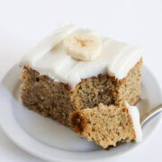 forkful of vegan banana cake with cream cheese frosting.