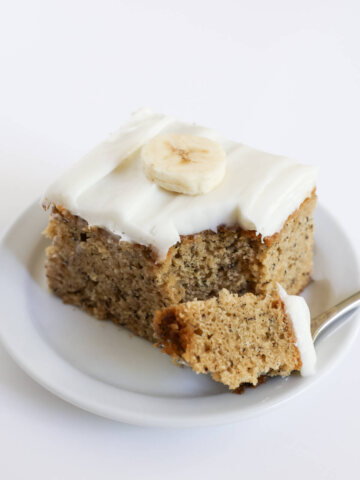 forkful of vegan banana cake with cream cheese frosting.