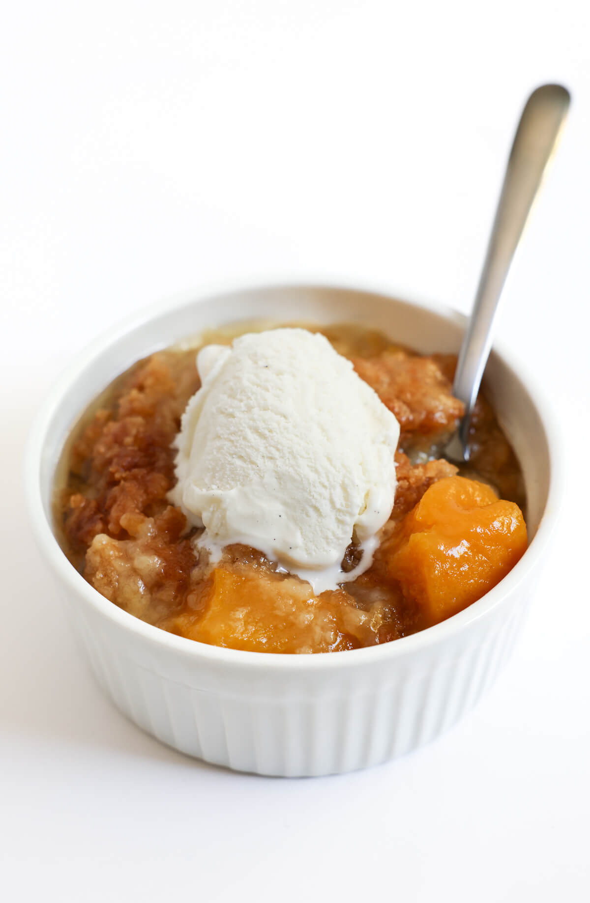 peach dump cake serving with vegan ice cream.