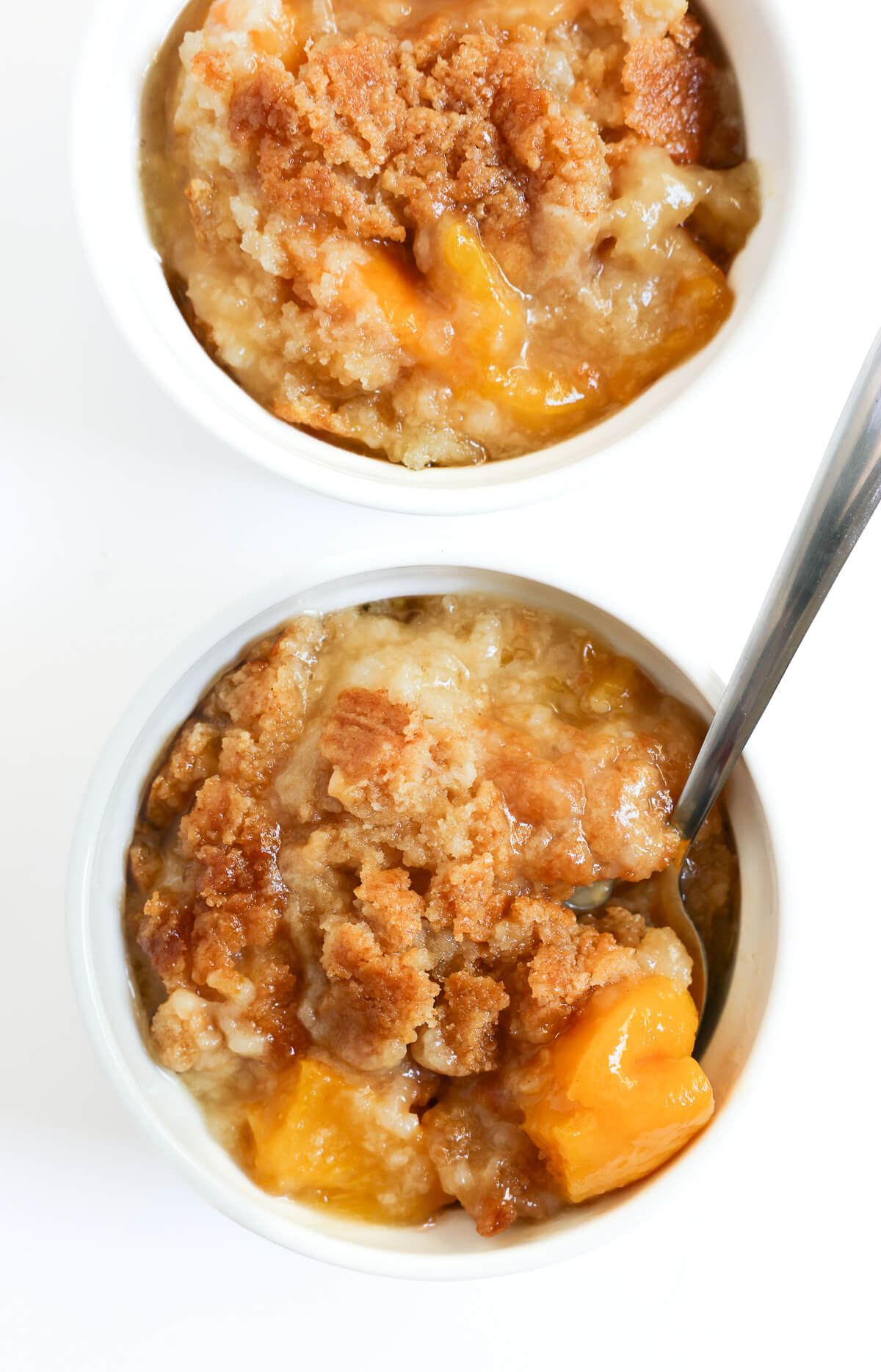 two ramekins with ready to serve gluten-free peach dump cake.