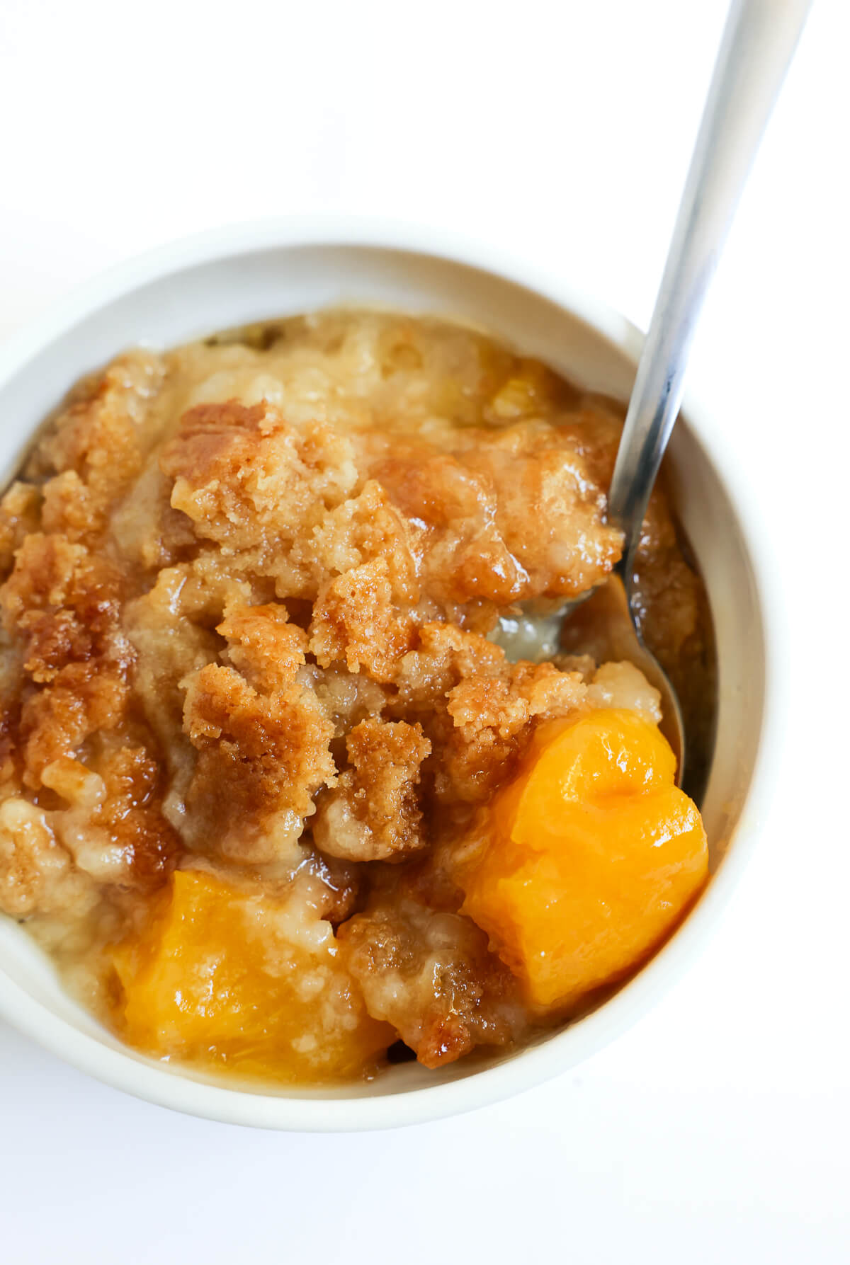 close up of spoonful of gluten-free peach dump cake.